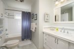 Hall bath with shower tub combo shared by additional bedrooms